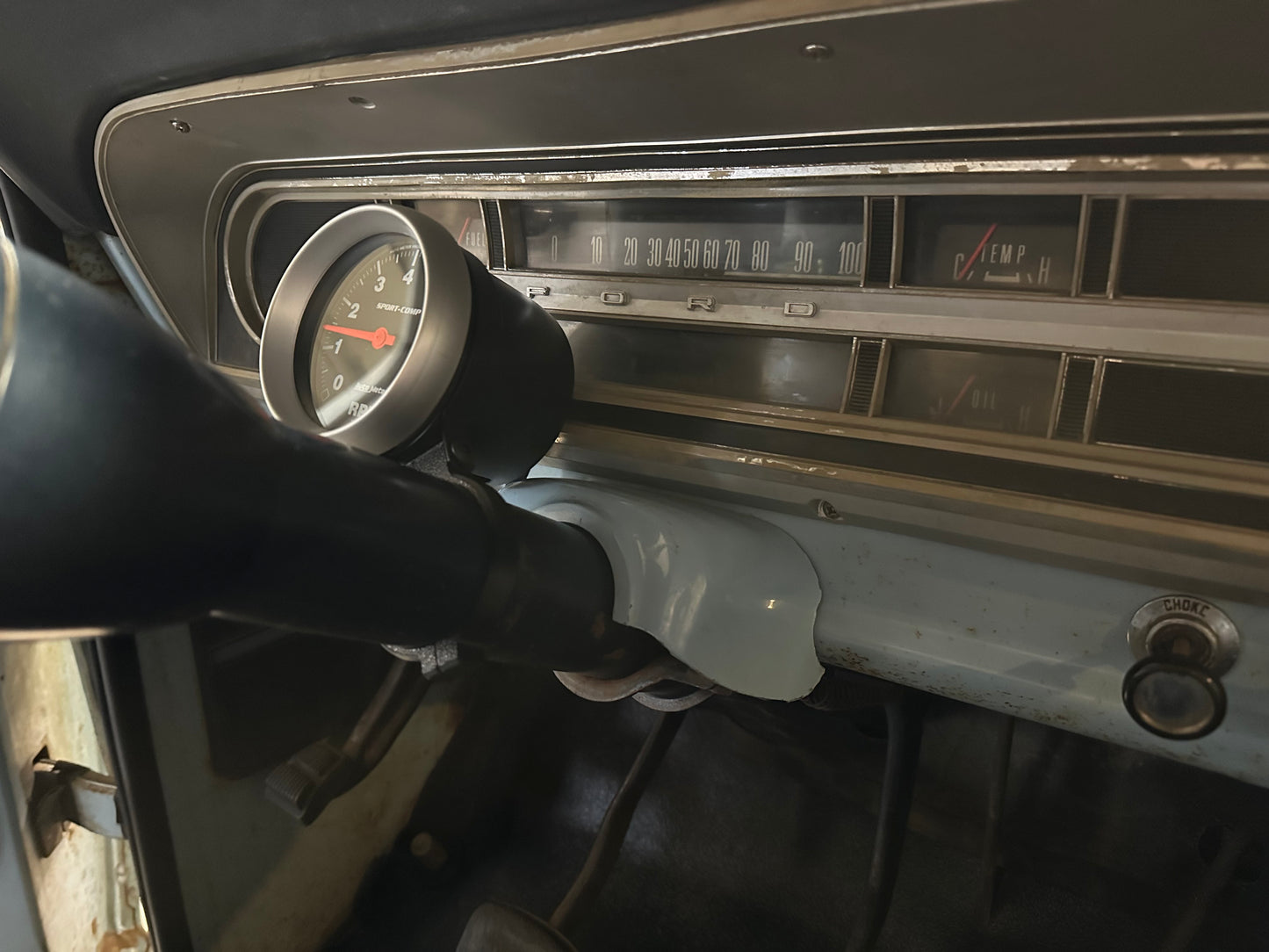 Steering column mount on a ford f100. Showing a tachometer with the gauge mount